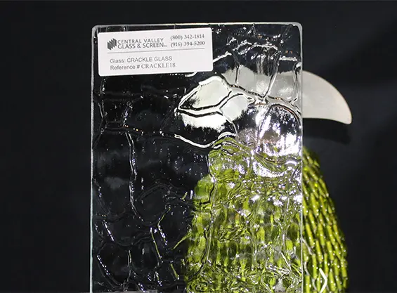crqck A glass sculpture of a parrot with green feathers.